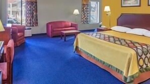 Habitación de hotel con cama, escritorio, silla y sofá.