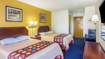 Habitació d'hotel amb dos llits, un escriptori i una cadira. Hi ha dues làmpades penjades a la paret i una porta que condueix a una altra habitació.