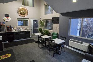 A breakfast area with a counter, seating, and a large window. - Super 8 by Wyndham Belleville St. Louis Area (Belleville)