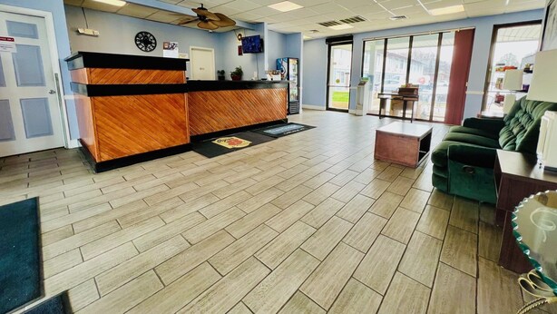 A reception area with a wooden reception desk, a clock, and a ceiling fan.
