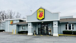 A Super 8 by Wyndham hotel with a modern design, featuring a prominent yellow and red sign, a glass entrance, and a parking lot.