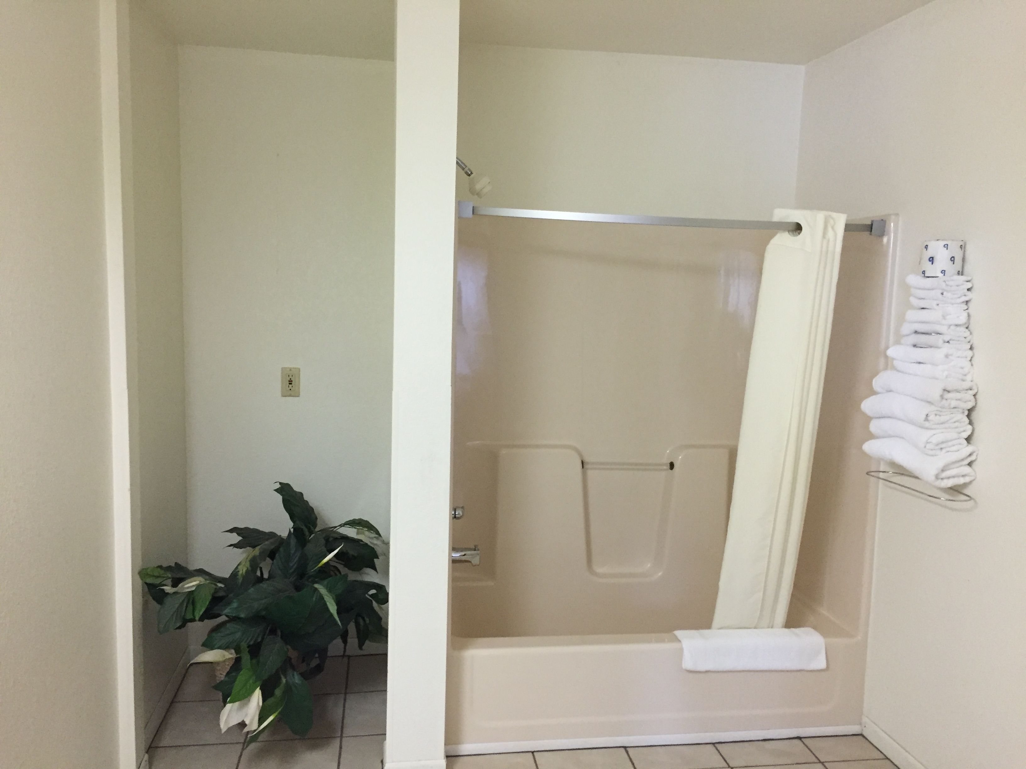 A bathroom with a bathtub, a shower curtain, and a towel rack.