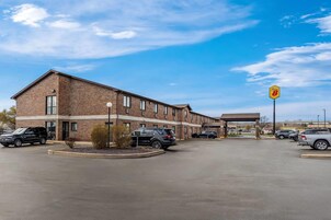 A brick building with a parking lot, a sign for Route 8, and several parked cars.
