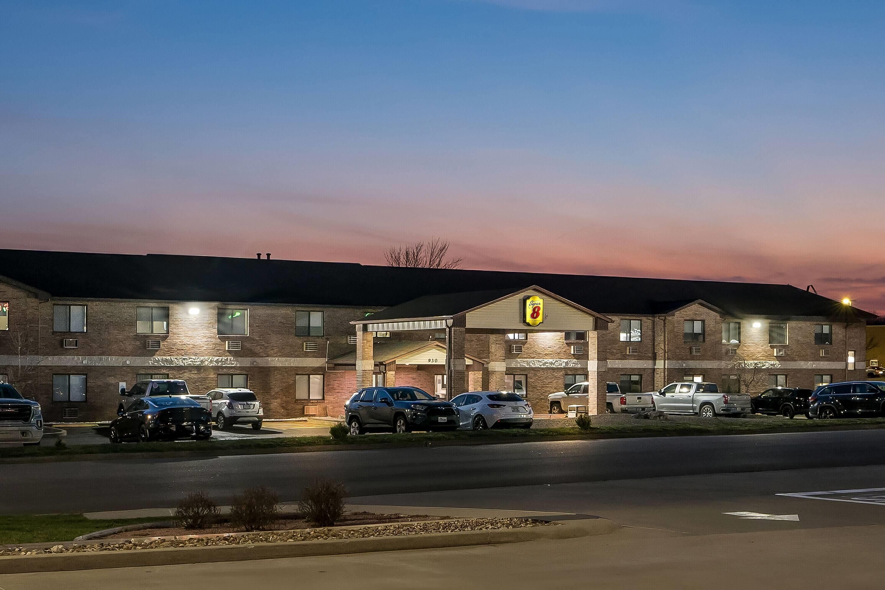 A motel with a brick facade, multiple parking spaces, and a sign indicating the number 910.