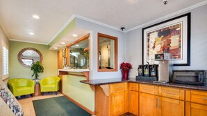 A kitchen with wooden cabinets, a microwave, and a sink. - Americas Best Value Inn Richmond San Francisco (Richmond)