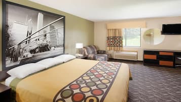 Habitación de hotel con una cama grande, un sofá, un televisor y una pintura de paisaje urbano.