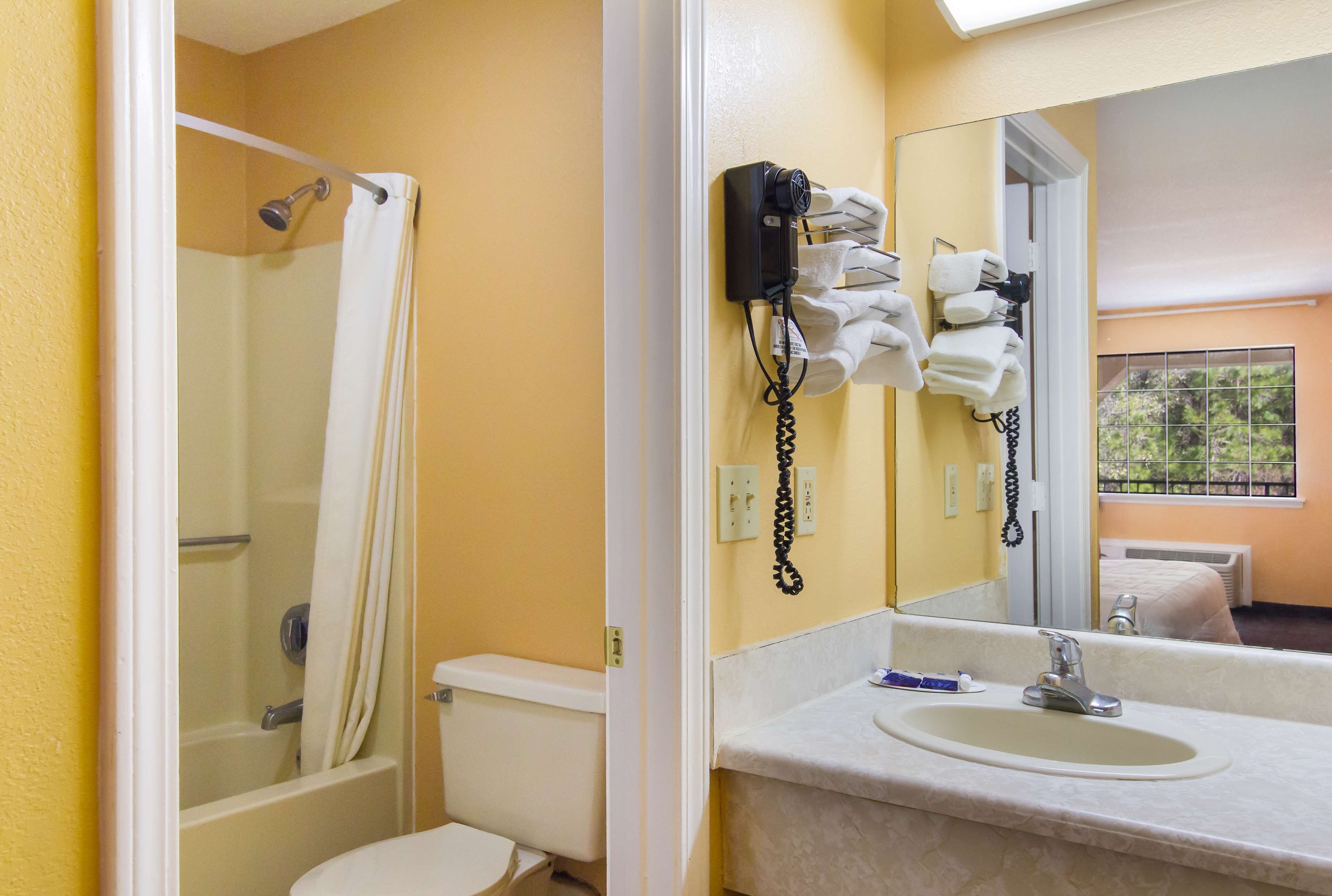 A bathroom with a shower, toilet, and sink.