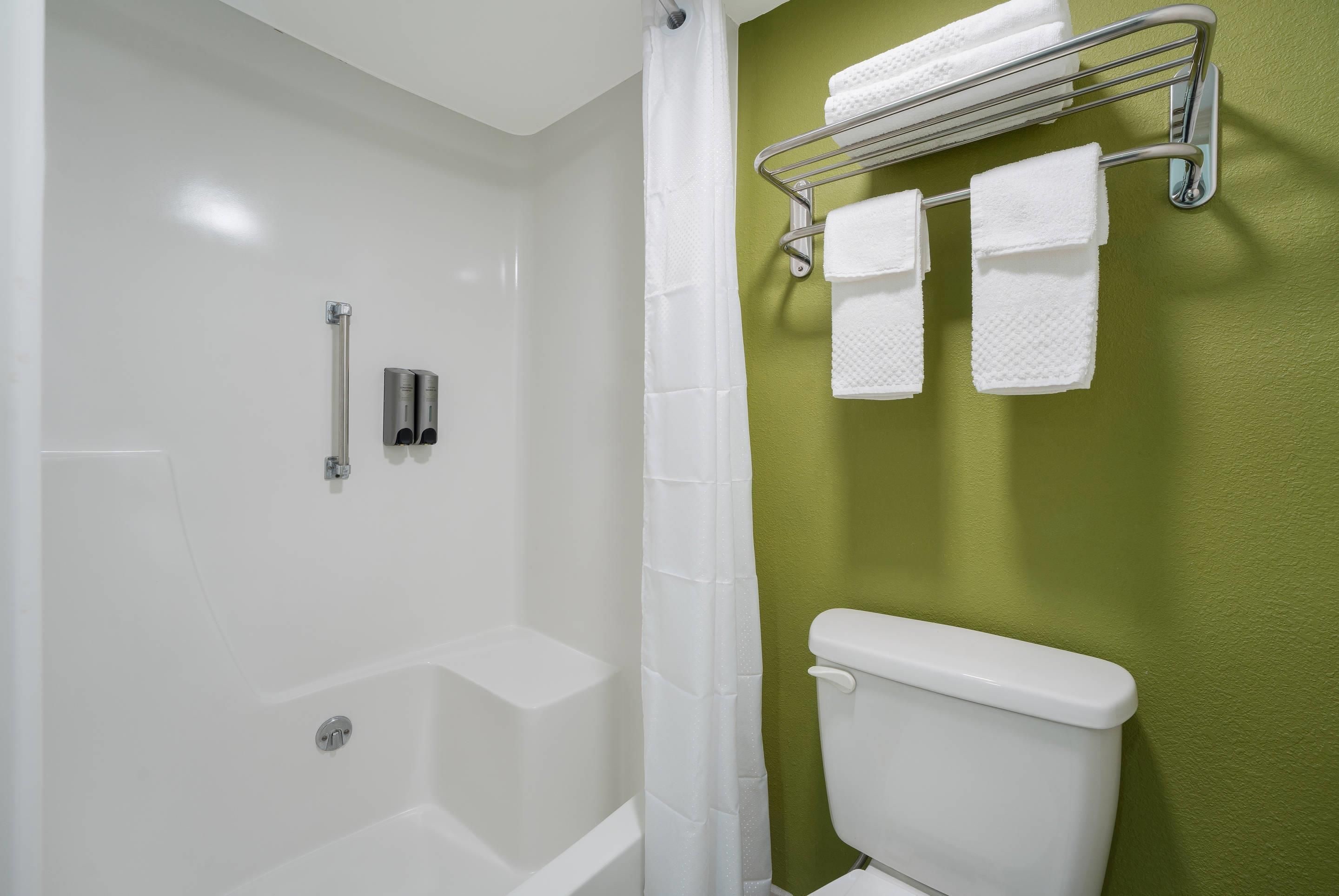 A bathroom with a bathtub, a toilet, and a towel rack.