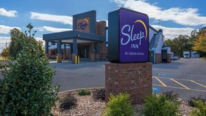 A Sleep Inn by Choice Hotels with a modern building, a parking lot, and a clear sky. - Sleep Inn Madison (Madison)