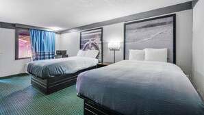 A hotel room with two beds, a large window with blue curtains, and artwork on the walls. - Super 8 by Wyndham Lantana West Palm Beach (Lantana)