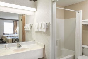 Un baño con lavabo, espejo y ducha.
