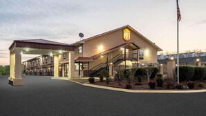 A hotel with a prominent 'Super 8' sign, a covered outdoor area, and a flagpole. - Super 8 by Wyndham Cleveland (Cleveland)