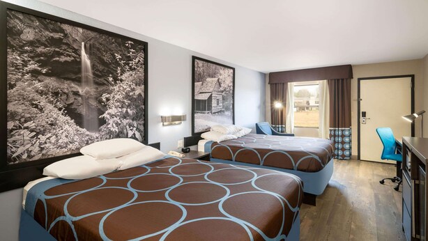 A hotel room with two beds, a desk, a chair, and a large window. - Super 8 by Wyndham Cleveland (Cleveland)