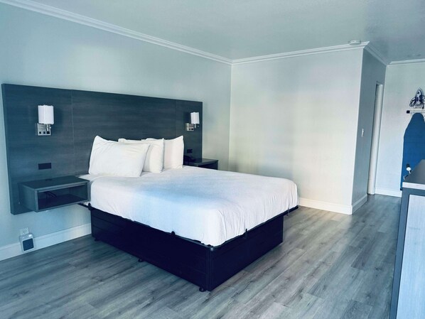 A modern bedroom with a large bed, bedside tables, and a nightstand.