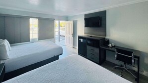 A hotel room with two beds, a flat-screen TV mounted on the wall, a desk with drawers, and a small office chair. - SureStay by Best Western Fresno Central (Fresno)