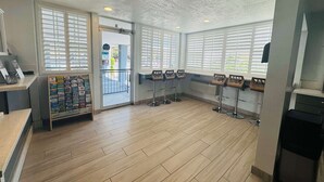 A spacious room with wooden flooring, large windows with blinds, and a reception area with a display of travel brochures. - SureStay by Best Western Fresno Central (Fresno)