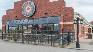 A brick building with a large circular sign reading "Bobbie's Bar & Grill" and a neon sign indicating the restaurant is open.