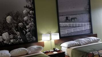 A hotel room with a bed, a nightstand with a lamp, a phone, and a painting of tulips.