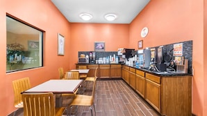 Un restaurante con muebles de madera, una barra con cafeteras y suelo de baldosas.
