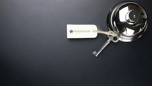 Ein Schlüssel mit einem Anhänger, auf dem 'Magnuson Hotels' steht, an einem Türgriff.
