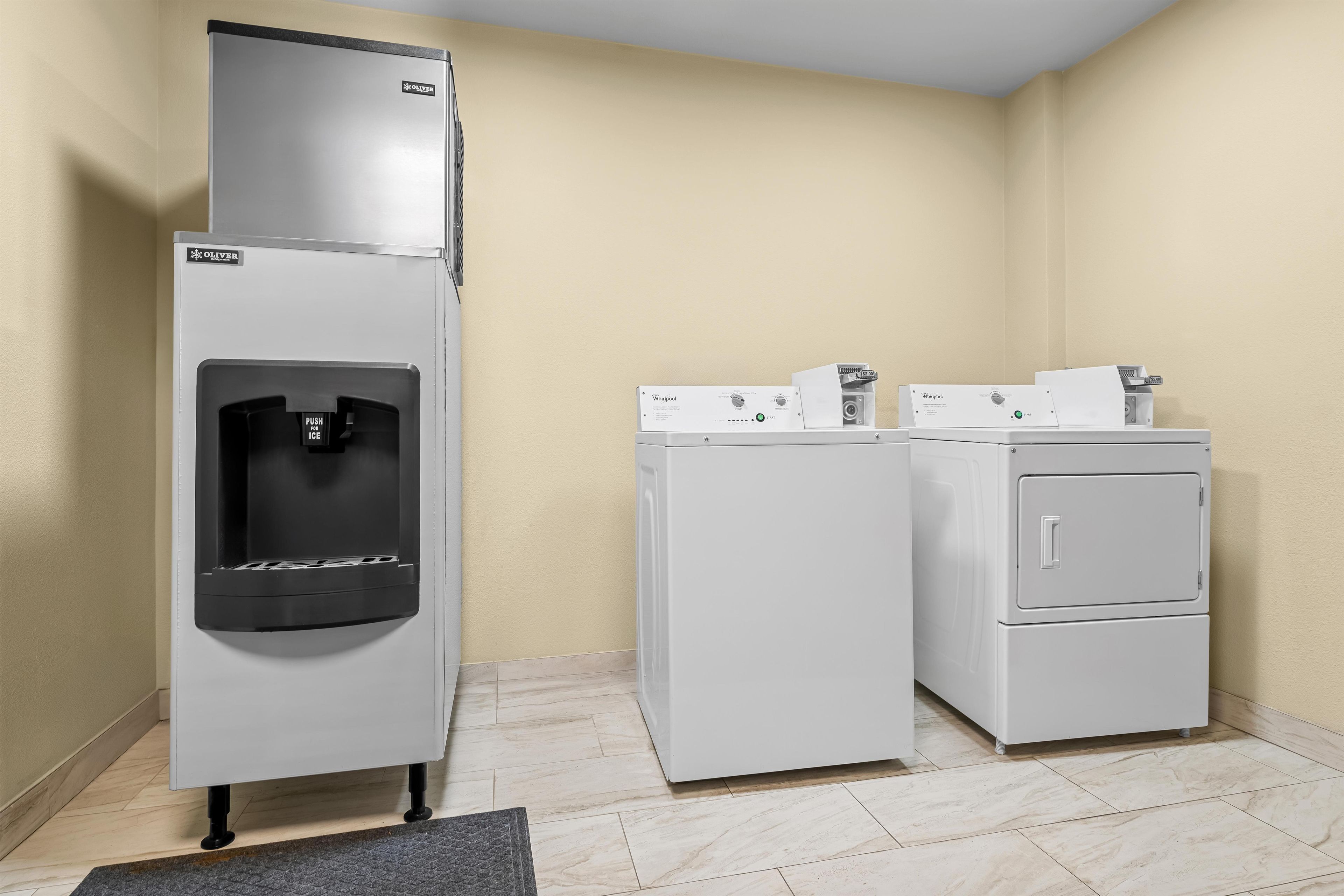 A compact laundry facility with a water dispenser, a washing machine, and a dryer.