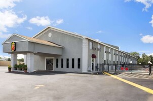 Un edificio moderno con techo plano, una entrada amplia y un estacionamiento.