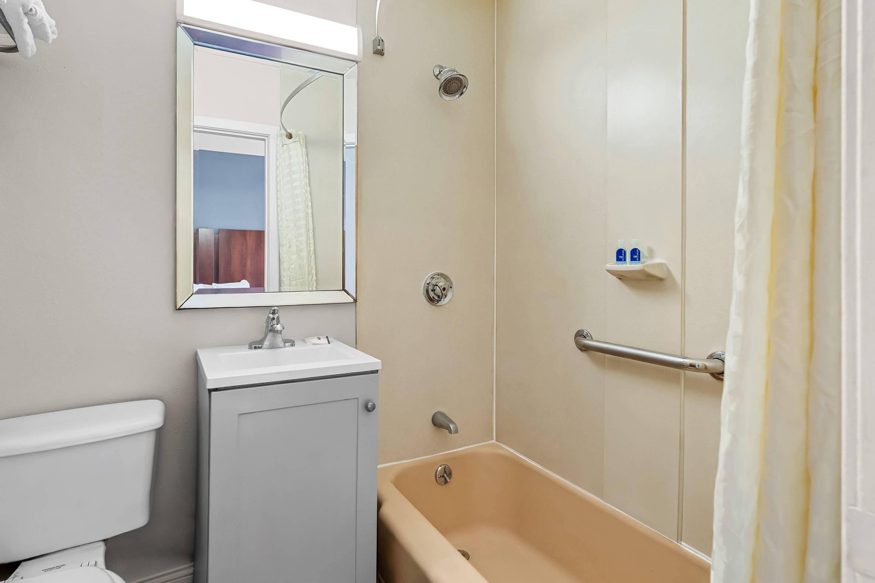 A bathroom with a toilet, sink, bathtub, and a shower with a glass door.