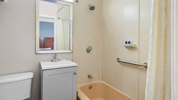 A bathroom with a toilet, sink, bathtub, and a shower with a glass door.