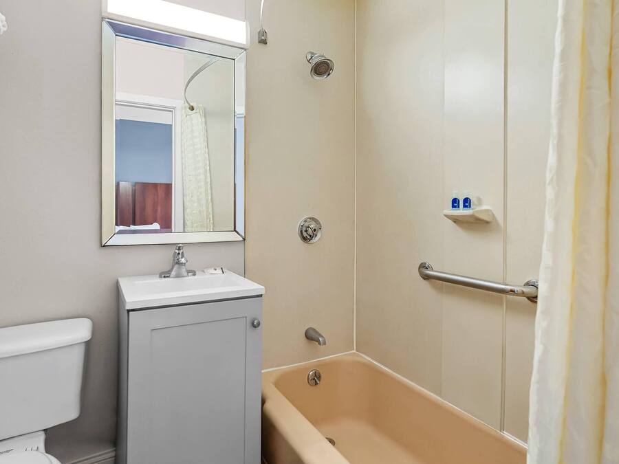 A bathroom with a toilet, sink, bathtub, and a shower with a glass door.