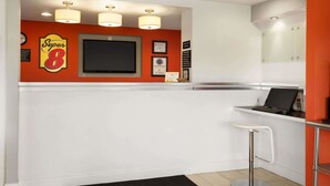 Una cocina moderna con un televisor de pantalla plana grande, una barra y un taburete blanco.