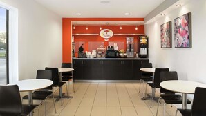 Un restaurante con mostrador, sillas y mesas.