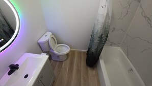 Un baño con inodoro, lavamanos y ducha.
