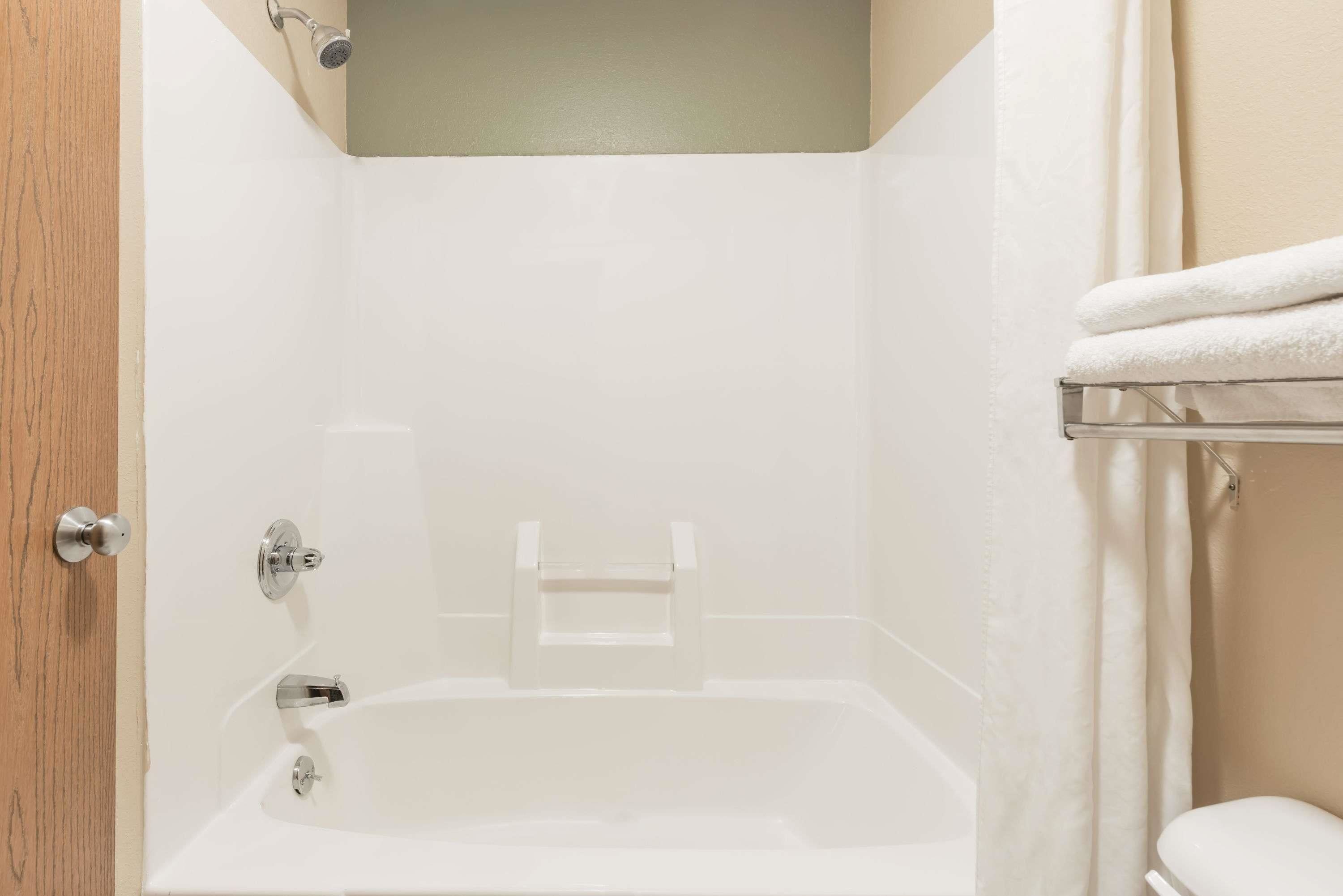 A bathroom with a bathtub, a toilet, and a towel rack.