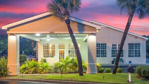 A hotel with a covered entrance, palm trees, and a number '1591' on the building. - SureStay Hotel by Best Western North Myrtle Beach (North Myrtle Beach)