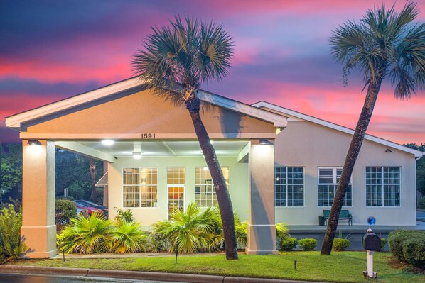 A hotel with a covered entrance, palm trees, and a number '1591' on the building. - SureStay Hotel by Best Western North Myrtle Beach (North Myrtle Beach)