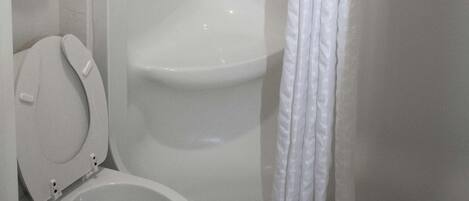 A bathroom with a toilet, a shower, and a towel rack.