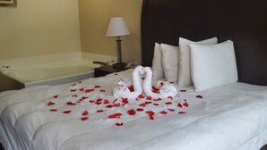 A hotel room with a large bed, a bedside table, a lamp, a telephone, and a bathtub. - SureStay Hotel by Best Western North Myrtle Beach (North Myrtle Beach)