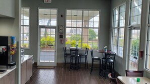 A spacious indoor area with a wooden floor, large windows, and a seating arrangement. - SureStay Hotel by Best Western North Myrtle Beach (North Myrtle Beach)
