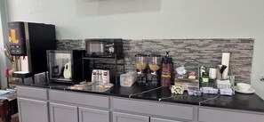 A kitchen area with a coffee machine, microwave, toaster, and various food items on the counter. - Super 8 by Wyndham San Marcos (San Marcos)