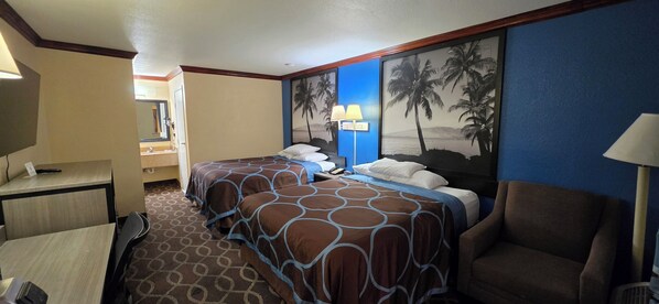 Une chambre d’hôtel avec deux lits, un bureau, une chaise et une grande fresque murale.