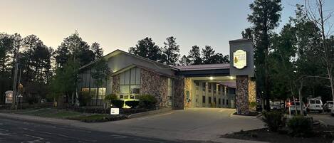 A building with a stone facade and a sign indicating it is a 1907 Pine Top Suites hotel.