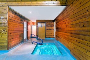 Interior de madera con zona de piscina, incluyendo una piscina azul, una escalera azul y paredes de madera.