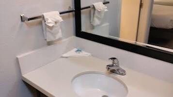 A bathroom with a white sink, a mirror, and a towel rack.