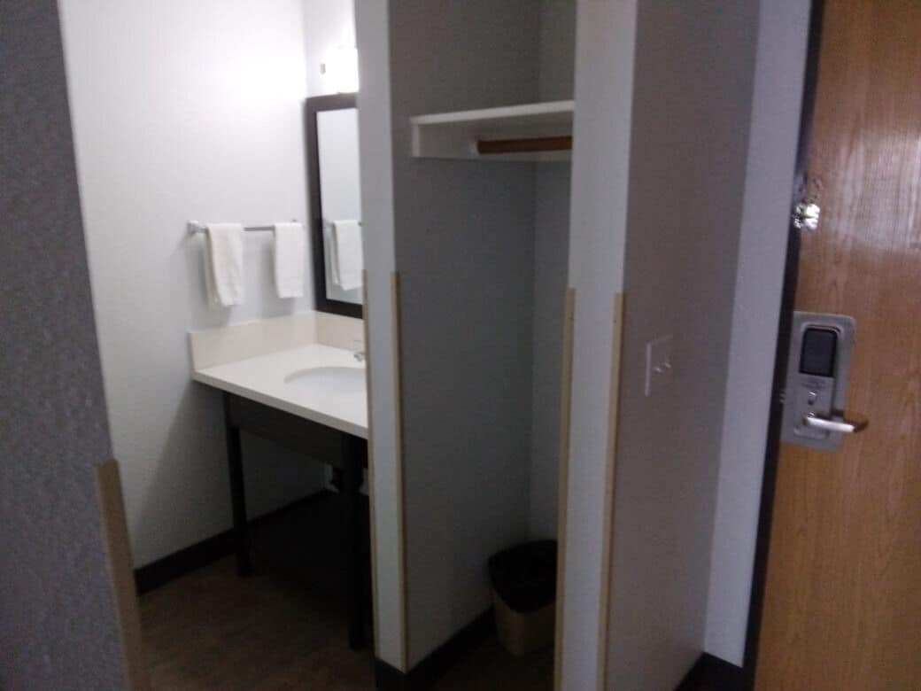 A bathroom with a white sink, a mirror, and a towel rack.