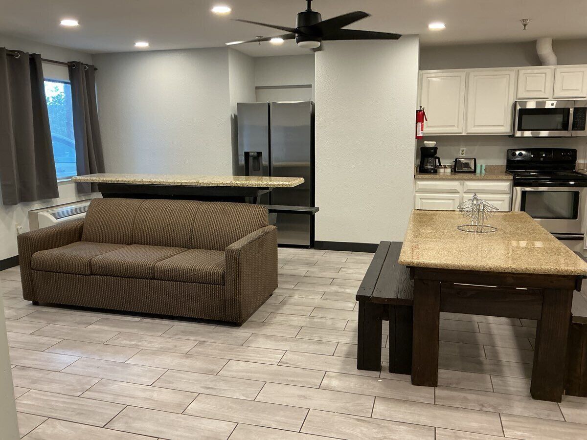 A modern kitchen with white cabinets, a built-in microwave, and a stainless steel refrigerator.