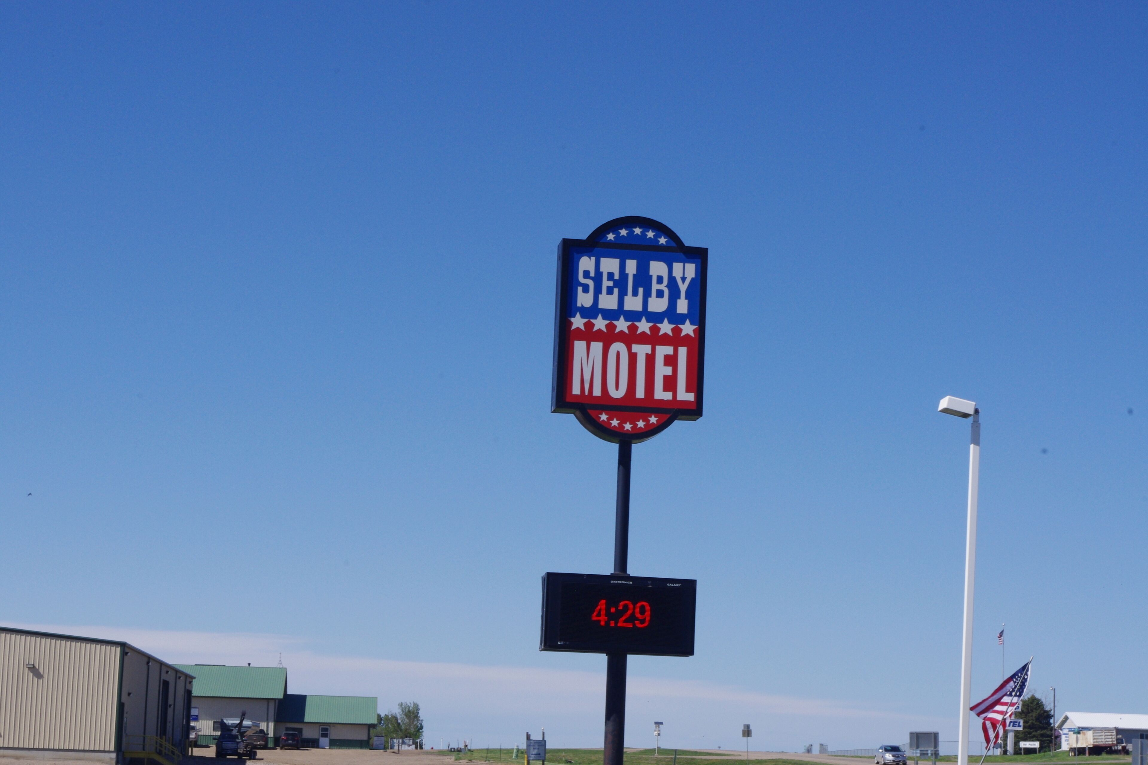 Un letrero de motel con el nombre 'Selby Motel' y un reloj digital que marca las 4:29.