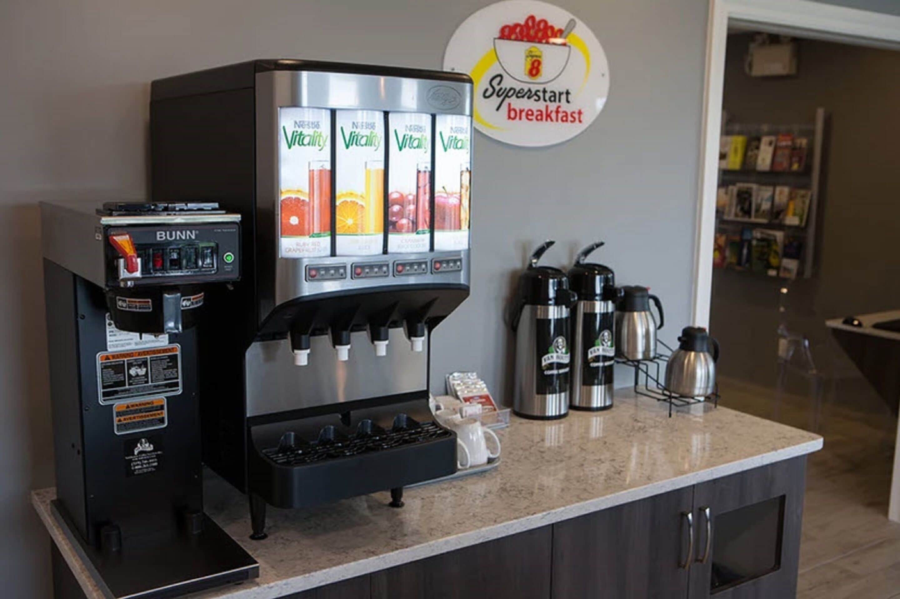 A coffee station with a Bunn espresso machine and a VitaMix juicer, along with two coffee makers on the counter.