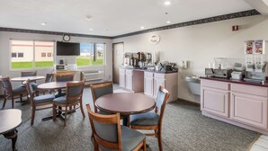 Une chambre d’hôtel avec un coin repas, une kitchenette et une vue sur un champ verdoyant.