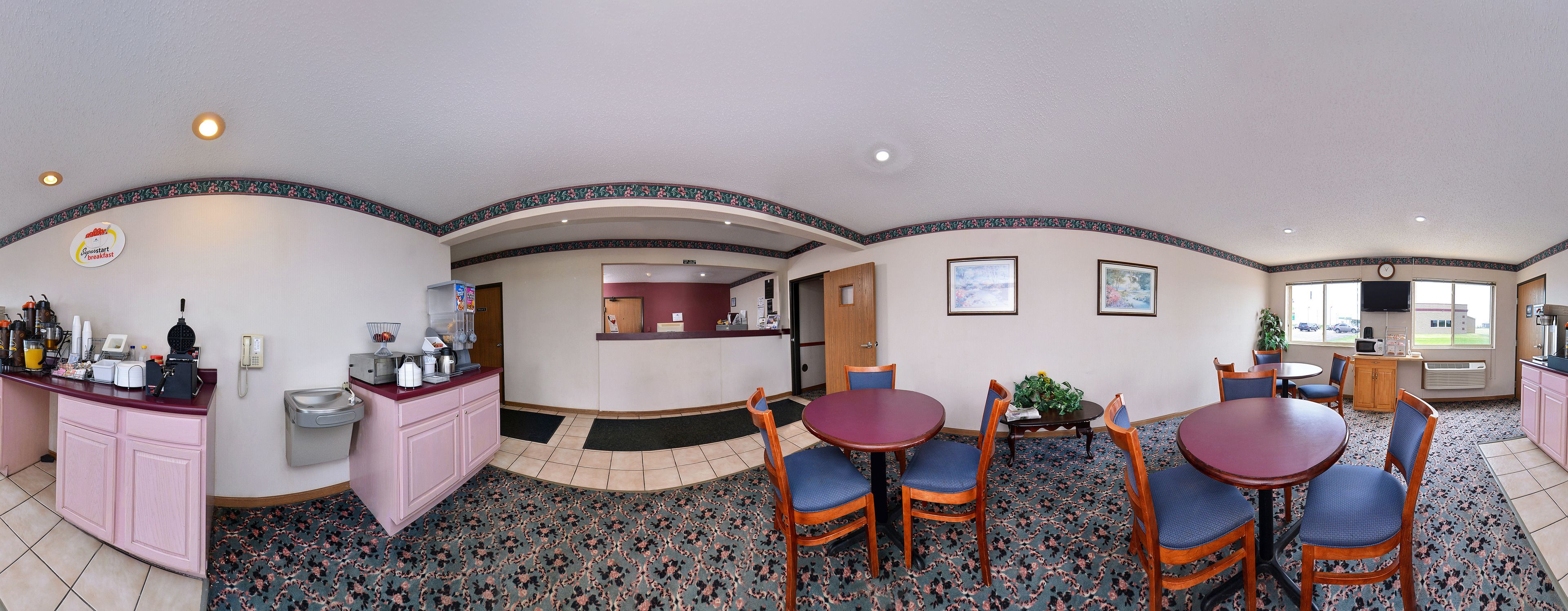 A breakfast area with a counter, chairs, and a dining table.