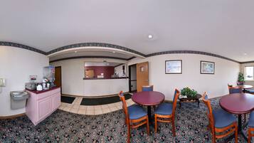 A breakfast area with a counter, chairs, and a dining table.